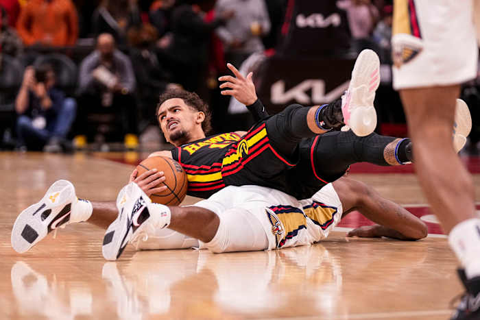 Trae Young reacts after ending up on top of Pelicans forward Naji Marshall.